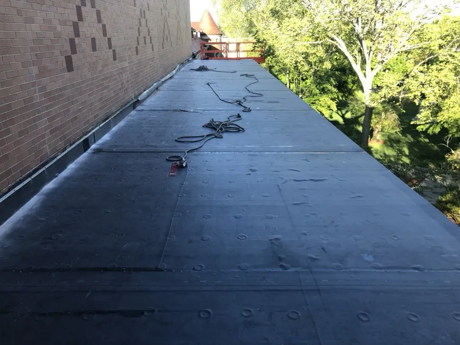 New metal counter-flashing installed along a brick wall