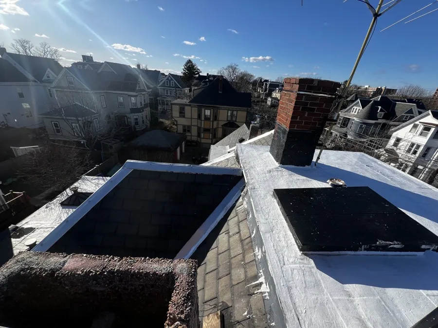 Slate roof and chimney flashing with the Boston skyline behind